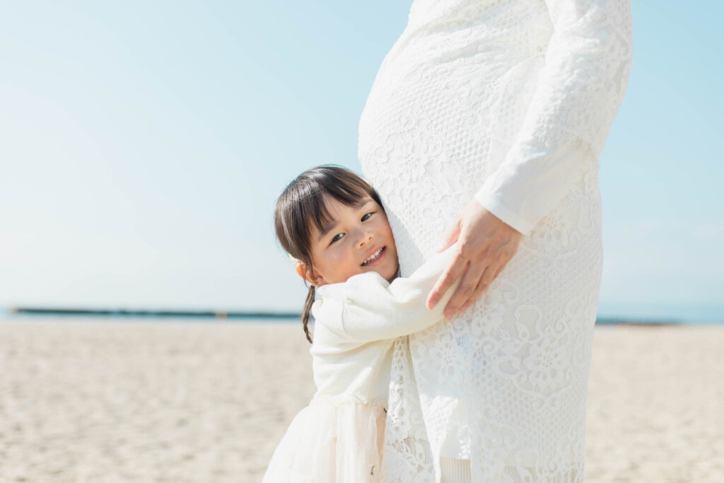 お腹の中の赤ちゃんにハグするお姉ちゃんの写真2