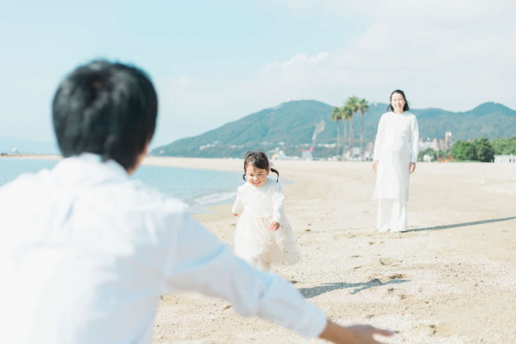 砂浜を走り回るお姉ちゃんの写真