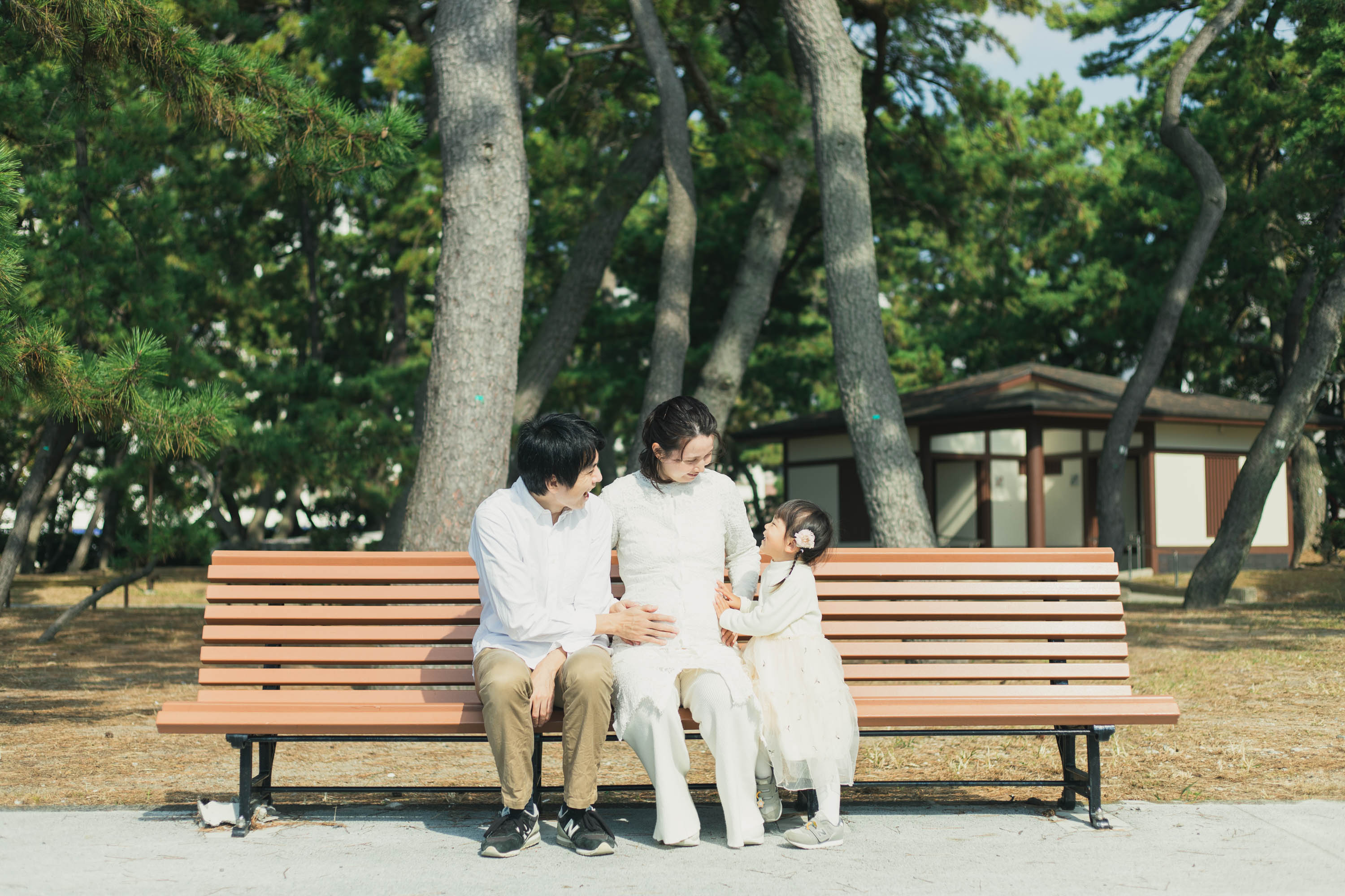 家族3人でベンチで笑い合っている写真