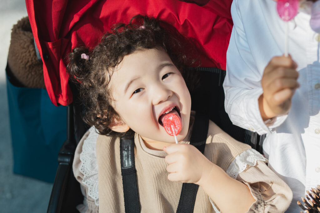 ペロペロキャンディーを舐める女の子の写真