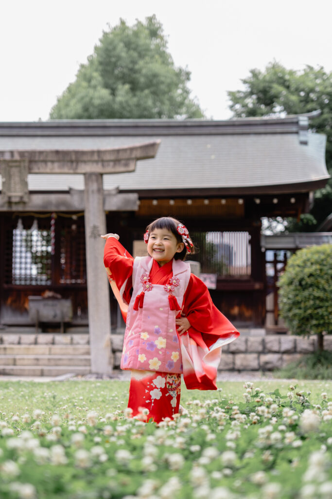 神社の中の切り株の上に立つ女の子の写真