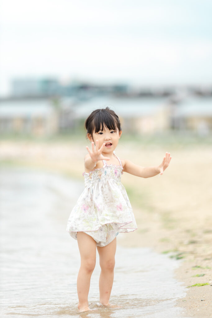 海辺で手のひらを見せる子供の写真