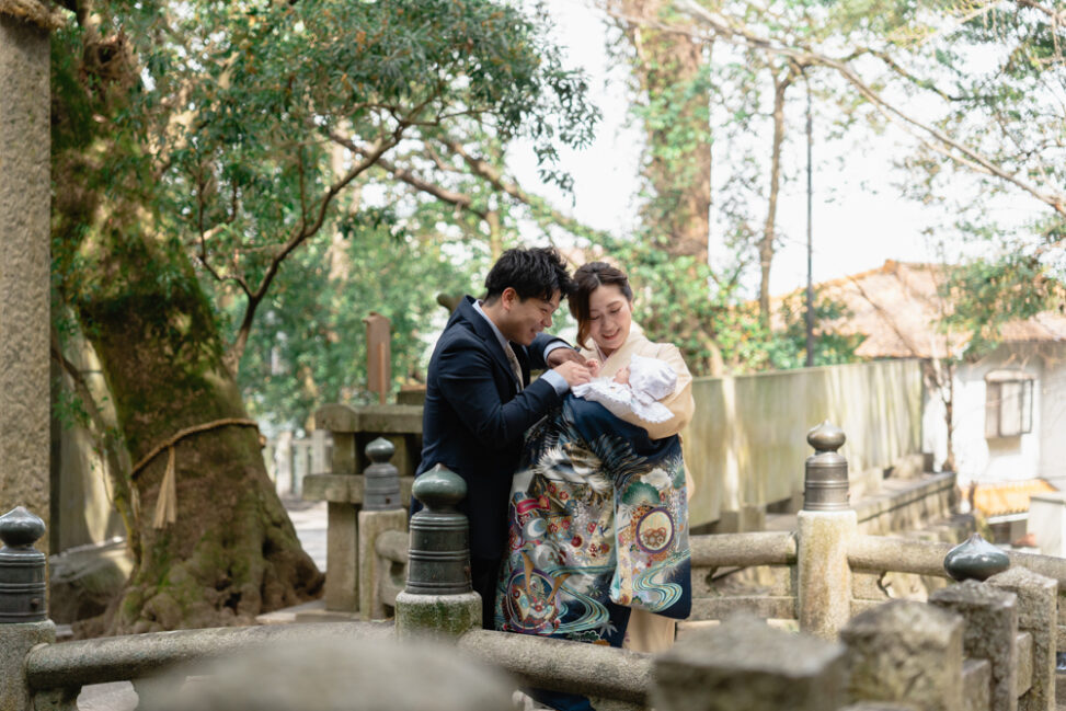 神社で赤ちゃんを囲み笑顔を見せる家族｜自然な表情を引き出すお宮参りの出張撮影